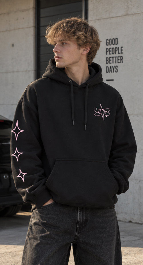 Sweat noir à capuche ORBITE vu de face, avec petit motif orbital rose clair sur la poitrine et trois étoiles sur la manche droite.