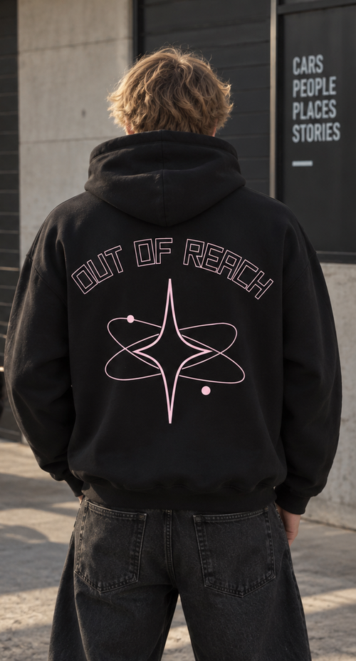 Sweat noir à capuche ORBITE vu de dos, avec inscription OUT OF REACH et grande étoile entourée d’orbites rose clair.