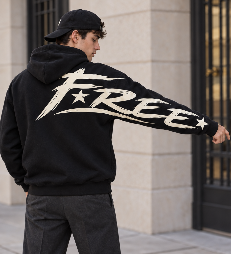 Sweat noir à capuche FREE vu de dos, bras droit tendu, avec grand lettrage clair et étoiles du haut du dos jusqu’à la manche.